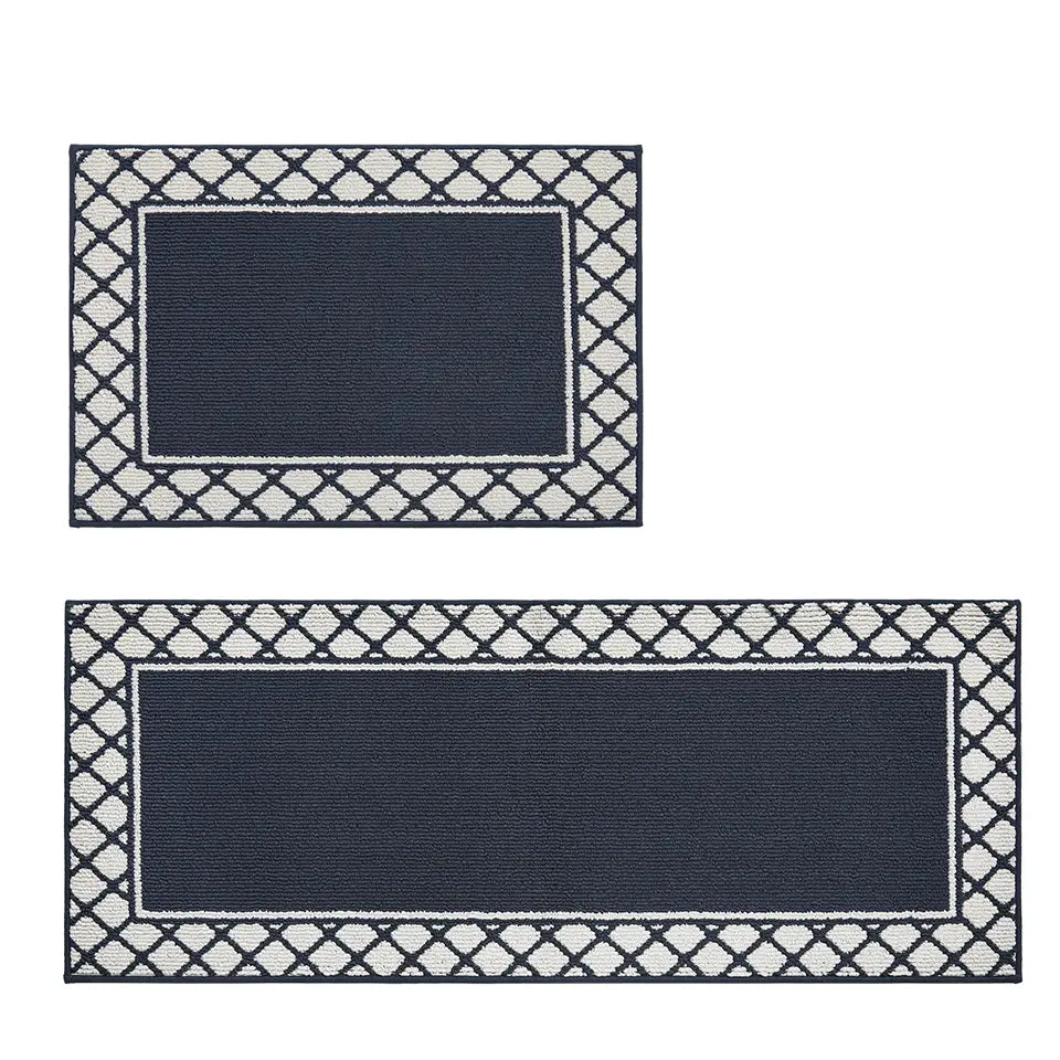 Two navy blue rectangular rugs with white geometric borders on a white background