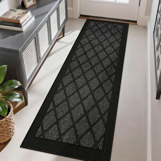 Dark gray patterned rug on a light wood floor in a room with a console table and plant.
