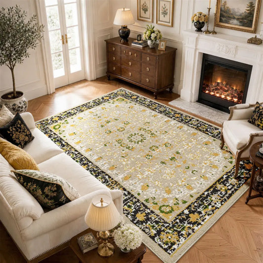 Living room with a gold & charcoal floral-patterned cozy area rug, sofa, and fireplace.