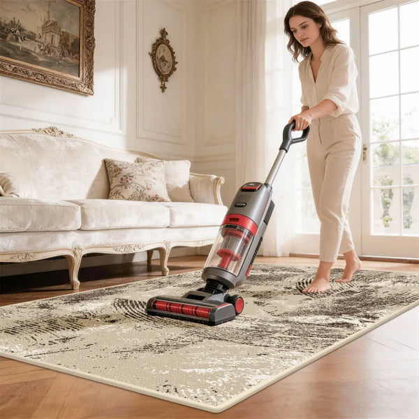 Woman using a vacuum cleaner on a patterned rug in a living room.
