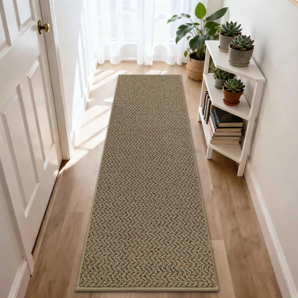 Long taupe woven runner rug on a wooden floor with a white door and bookshelf in the background.