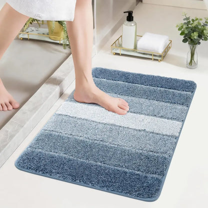 Blue striped bath mat on a bathroom floor with a person stepping onto it.