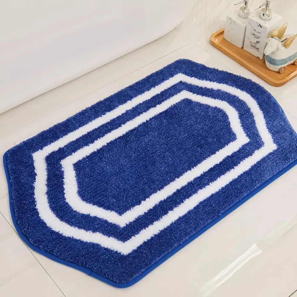 Blue bath mat with white border on a bathroom floor