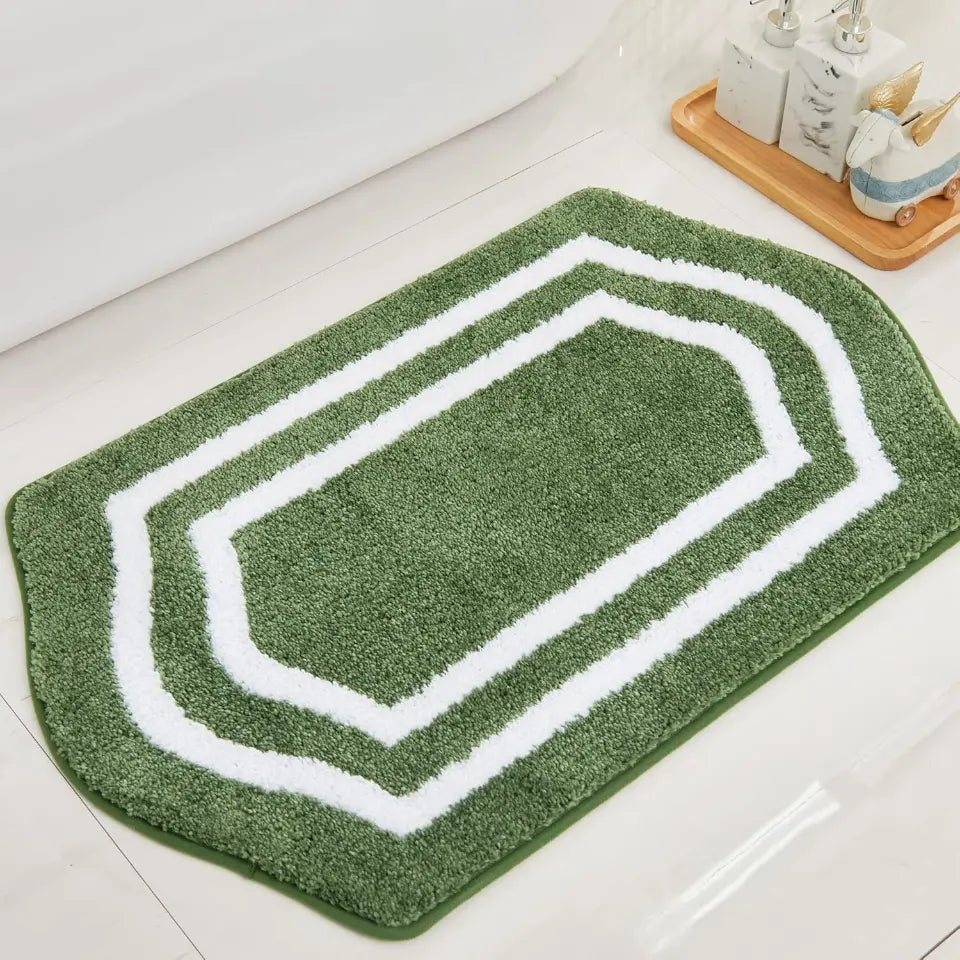 Green bath mat with white border on a bathroom floor