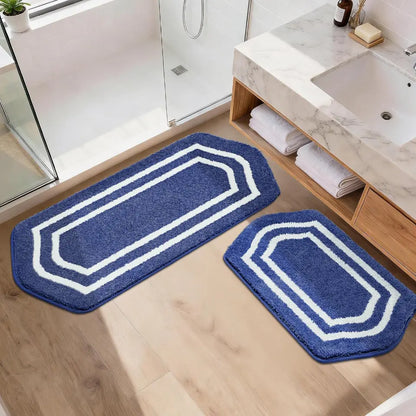 Set of two blue bath mats with white borders on a bathroom floor.