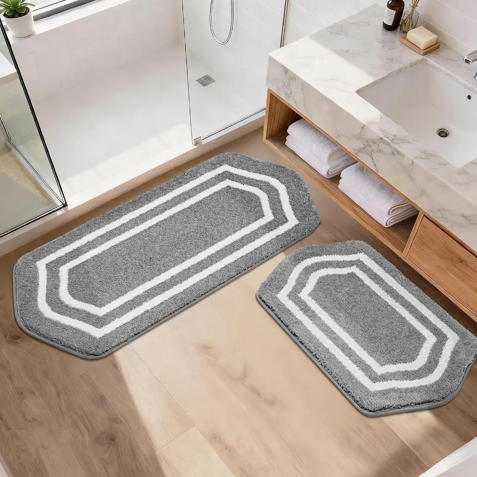 Grey bath mats with white border on a bathroom floor