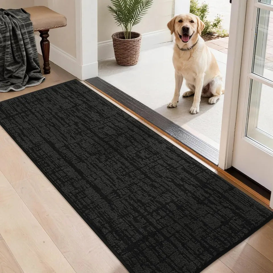 Dog standing on a black doormat at the entrance of a home