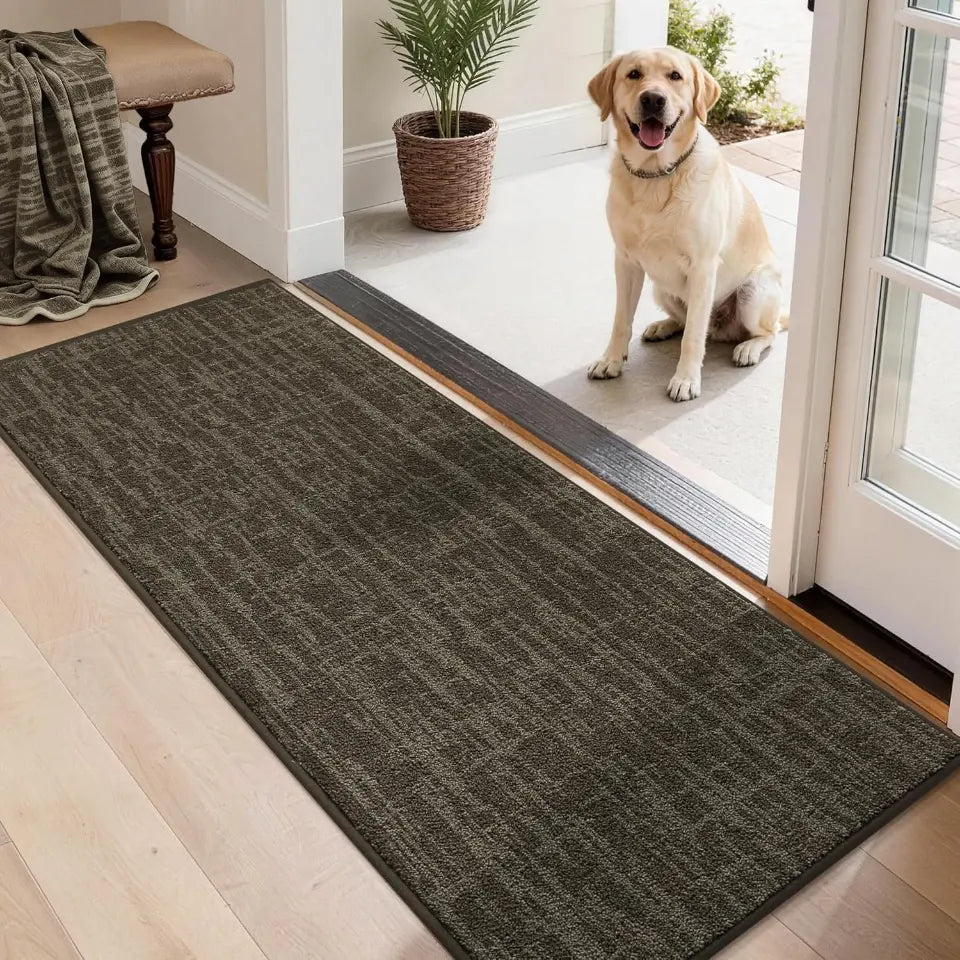 Dog standing on a brown doormat at the entrance of a home