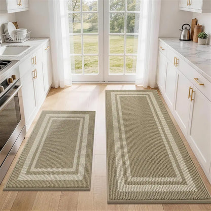Two beige white frame kitchen rugs on a wooden floor with a view of a garden through a window.