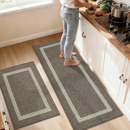 Person standing on a long brown rug with a white border in a kitchen.