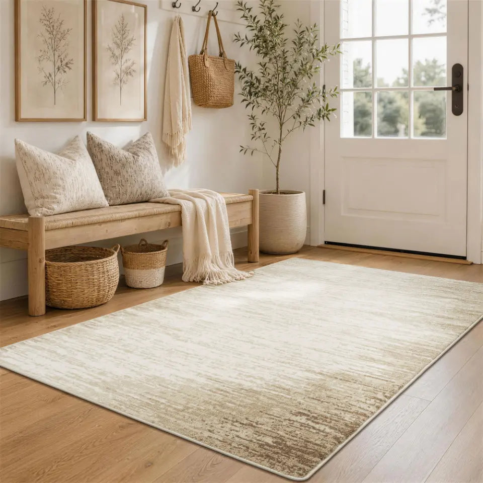 Nestled entryway with a bench, taupe & cream rug, and door.