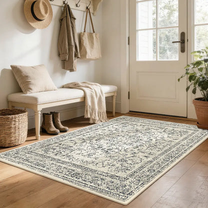 Nestled entryway with a faded grey & cream patterned rug, bench, and coat rack.