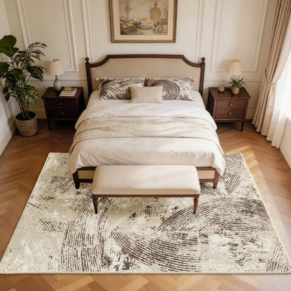 Neatly made bed with white bedding on a oatmeal & espresso patterned rug in a bedroom setting.