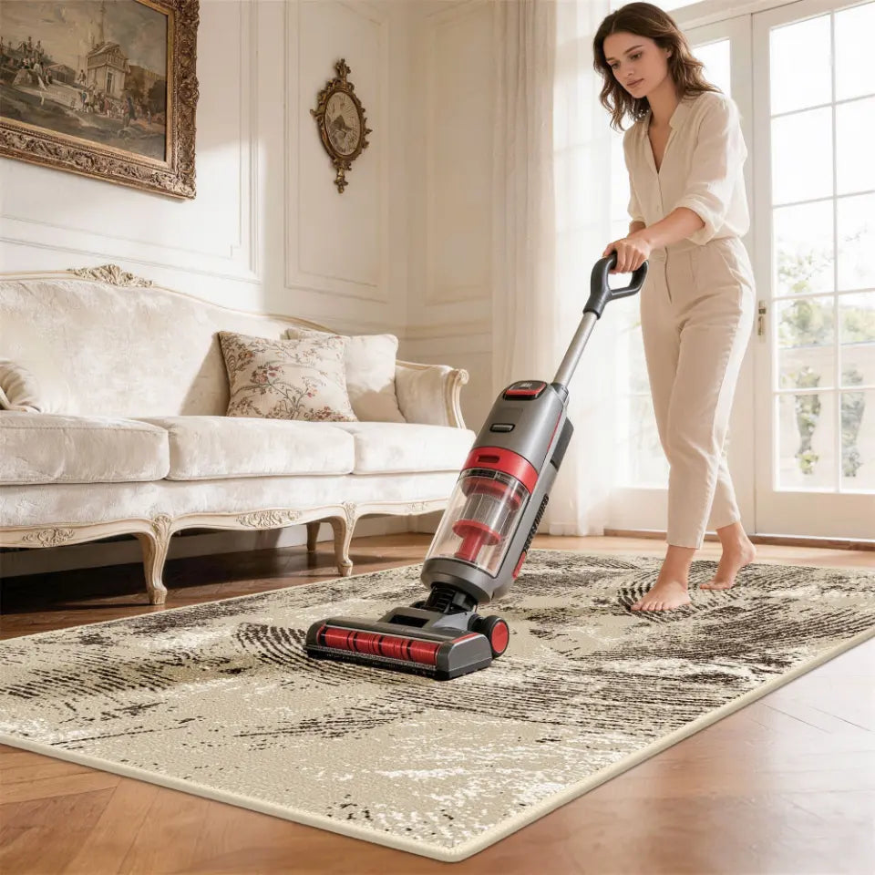 Woman using a vacuum cleaner on a patterned rug in a living room.