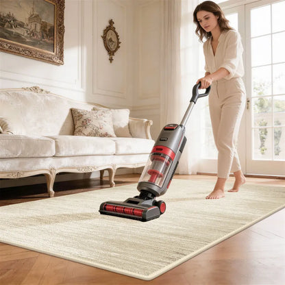 Woman using a vacuum cleaner on a rug in a living room.