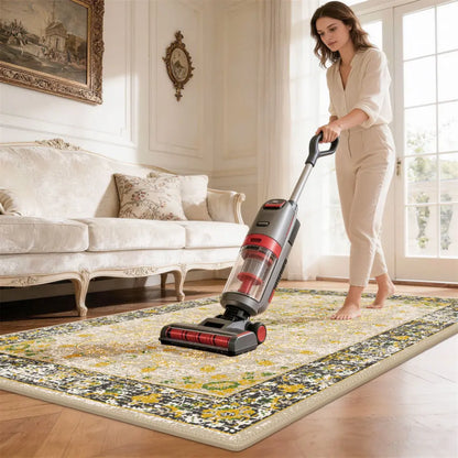 Woman using a vacuum cleaner on a patterned rug in a living room.