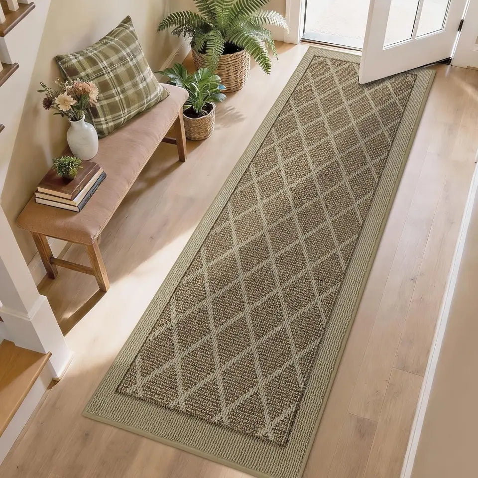 Beige long rectangular rug with a diamond pattern on a wooden floor, with a bench and plants in the background.