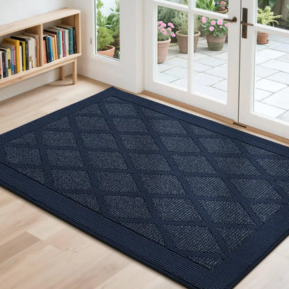 Navy blue doormat with diamond pattern on a wooden floor, leading to a glass door with outdoor view.