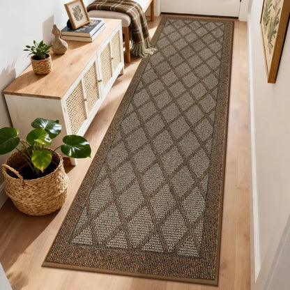 Patterned light brown rug on a wooden floor with a side table and plant in the background