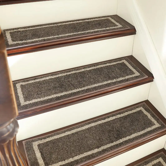 Staircase with dark brown wooden steps and gray carpet runners.