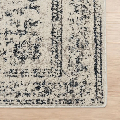 Close-up of a textured area rug with a pattern on a wooden floor.