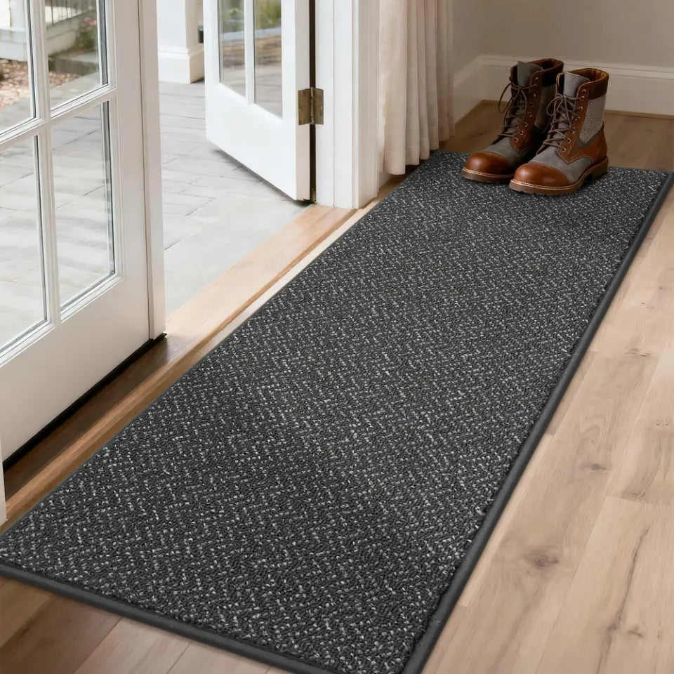 Dark Grey doormat with shoes on a wooden floor next to a glass door.