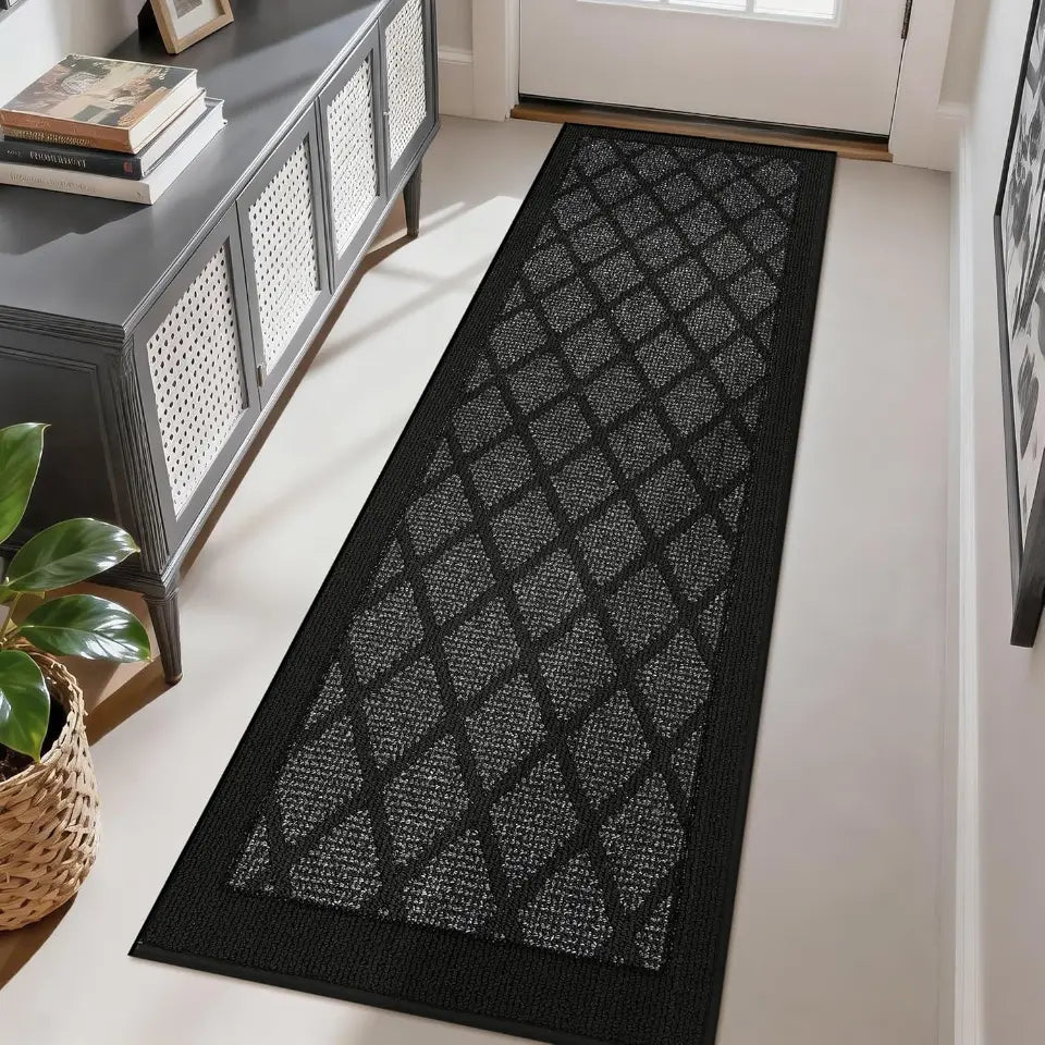 Dark grey patterned rug on a light wood floor in a room with a console table and plant.
