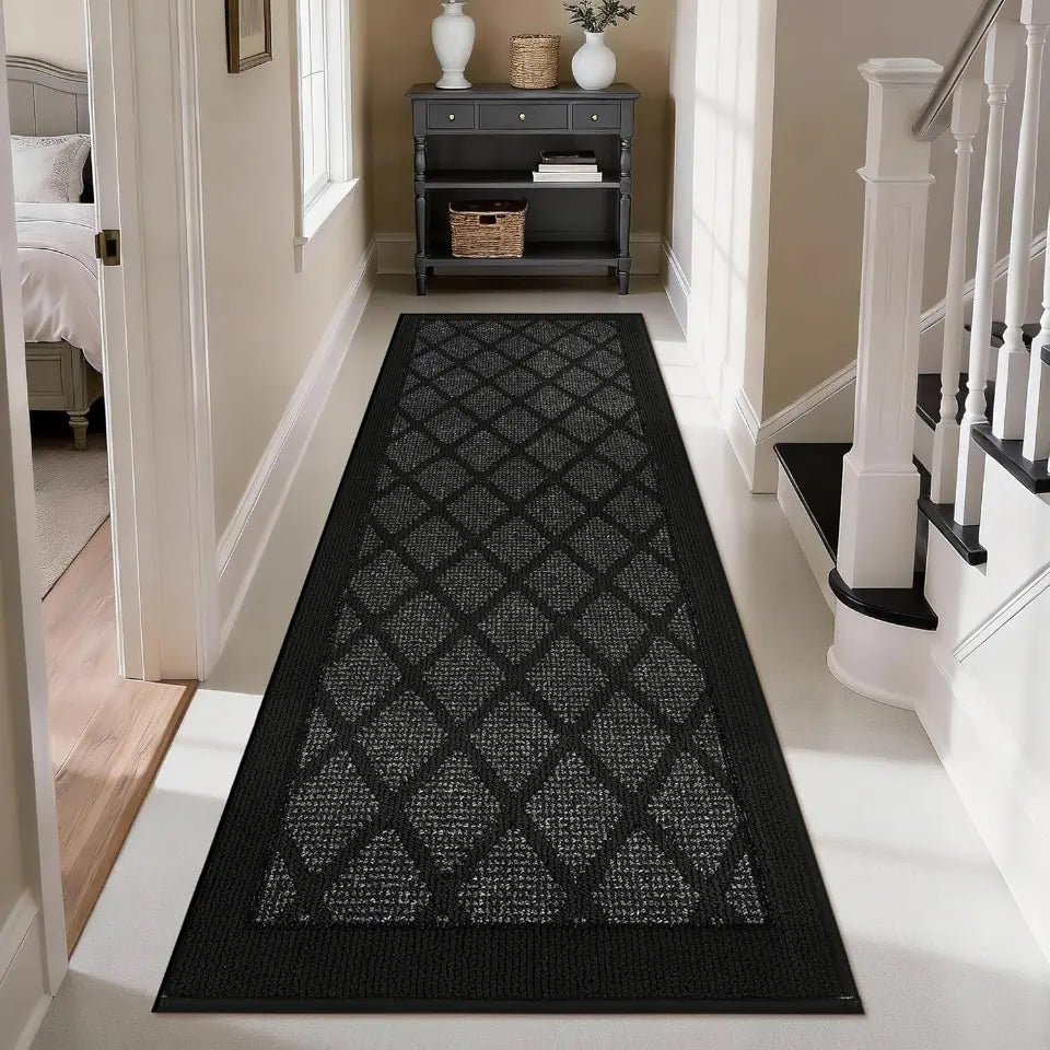 Dark grey patterned rug on a white floor in a home setting with a staircase and bedroom.