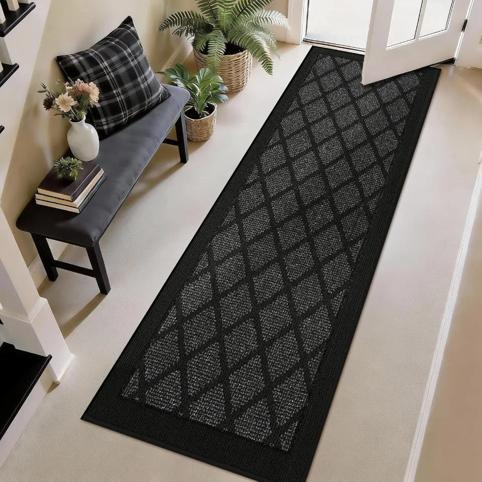 Dark grey diamond-patterned rug on a light wood floor with a bench and plants in the background.