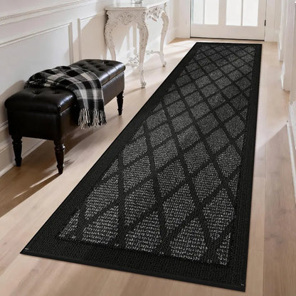 Dark grey patterned rug on a wooden floor in a room with a bench and plaid blanket.
