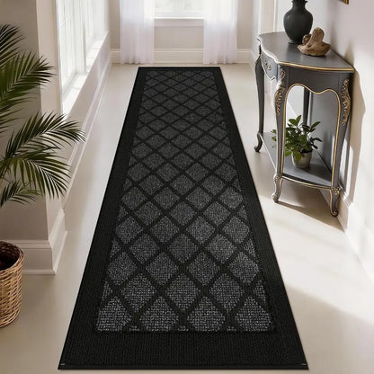 Dark grey patterned rug on a light wooden floor with a side table and plants in the background.