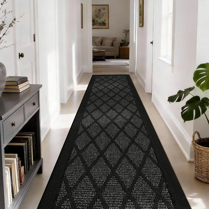 Long dark grey patterned rug in a hallway with a bookshelf and plant on a white floor.