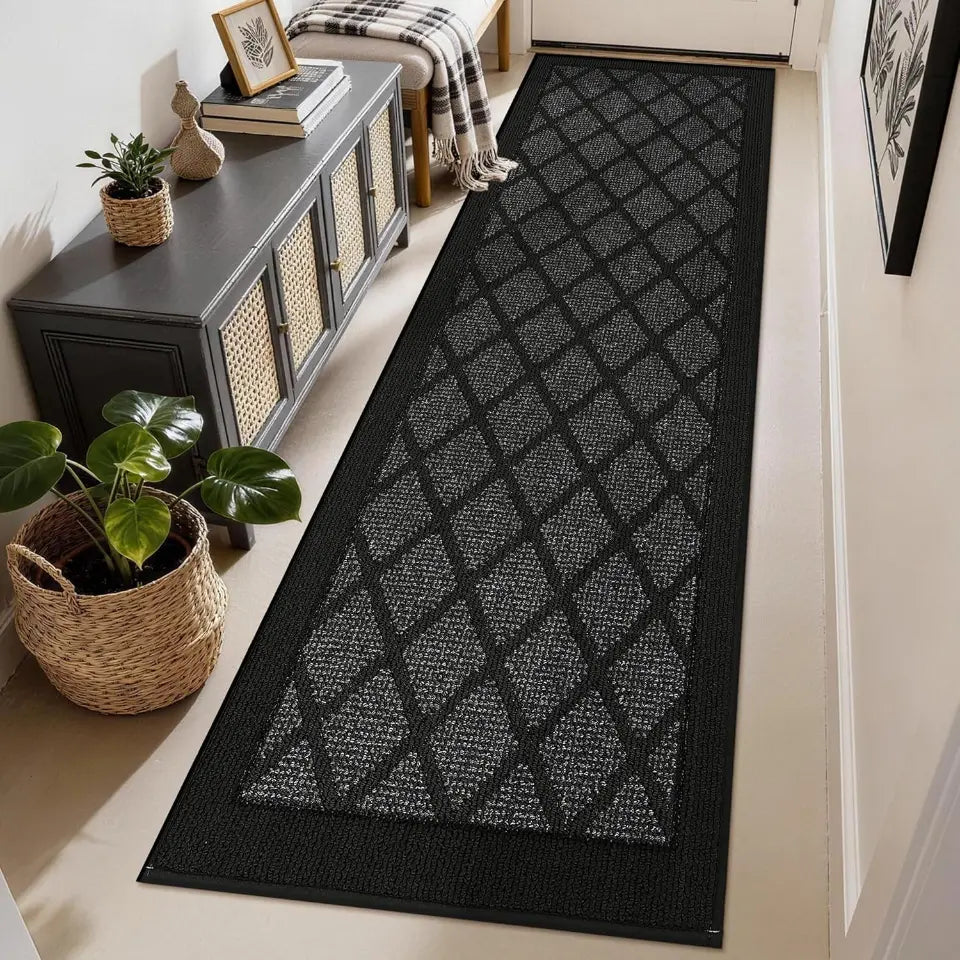 Dark grey geometric patterned rug on a light wood floor in a home setting.