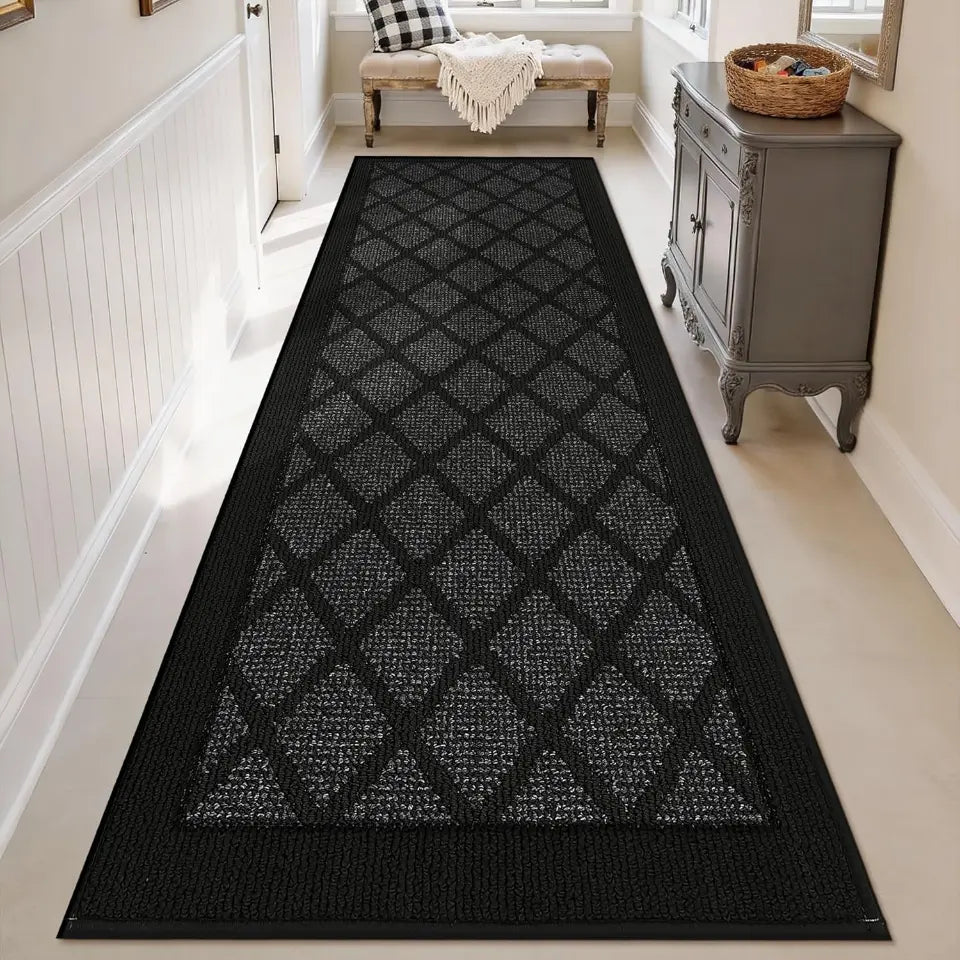 Dark grey geometric patterned rug on a light wood floor in a home setting.