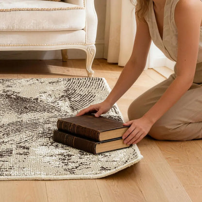 Person arranging books on a patterned rug to flatten the corner of rug