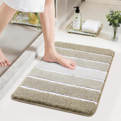 Person stepping onto a beige High Contrast striped bath mat in a bathroom setting.