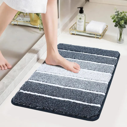 Person stepping onto a dark blue High Contrast striped bath mat with a bathroom setting in the background.