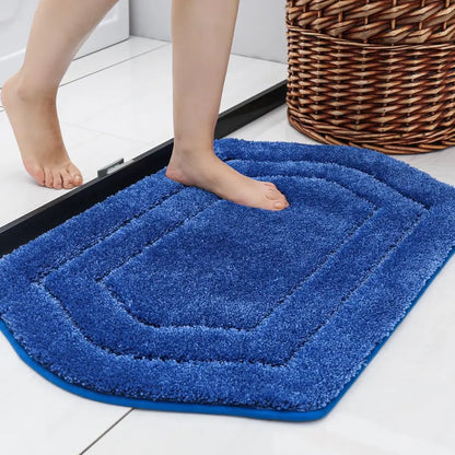 Blue bath mat on a floor with a person stepping onto it