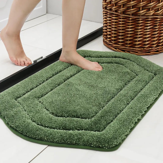 Green bath mat on a floor with a wicker basket in the background