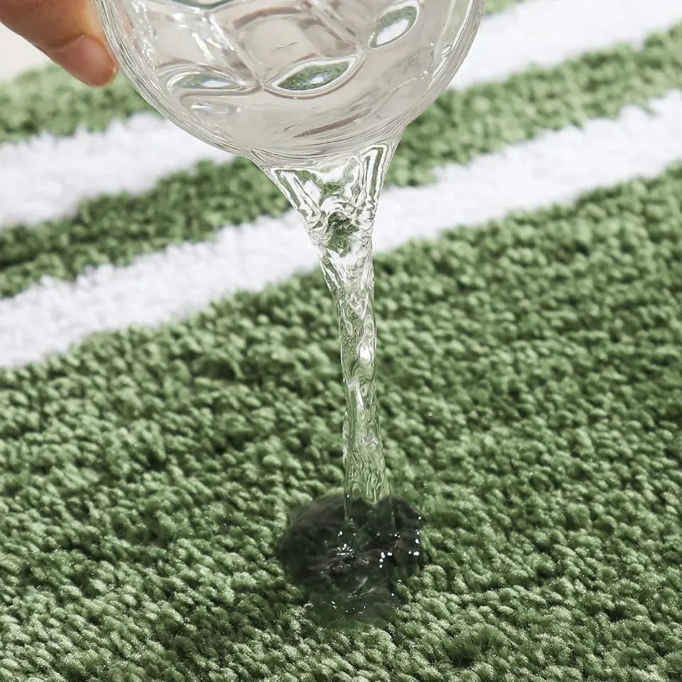 Clear liquid being poured from a glass container onto a small object on a surface.