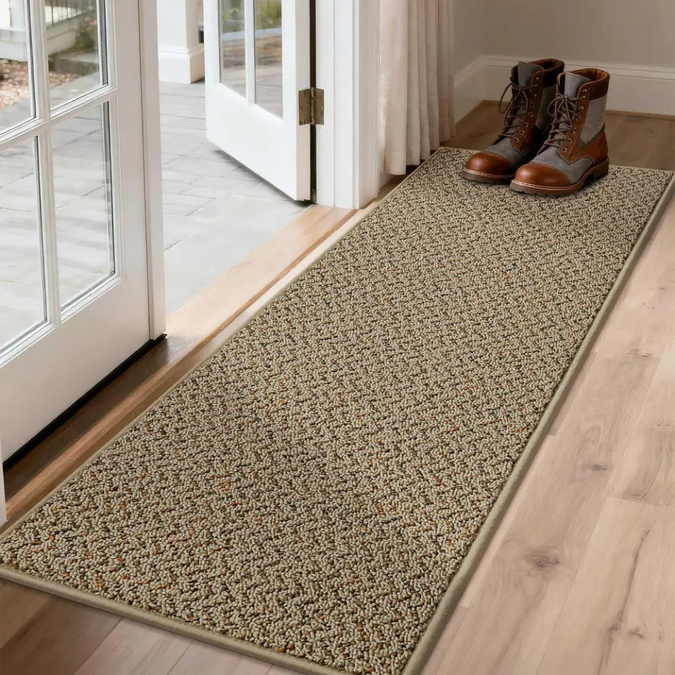 Taupe doormat with shoes on a wooden floor near a glass door.