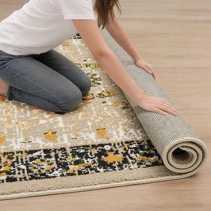 Person unrolling a patterned rug on a wooden floor
